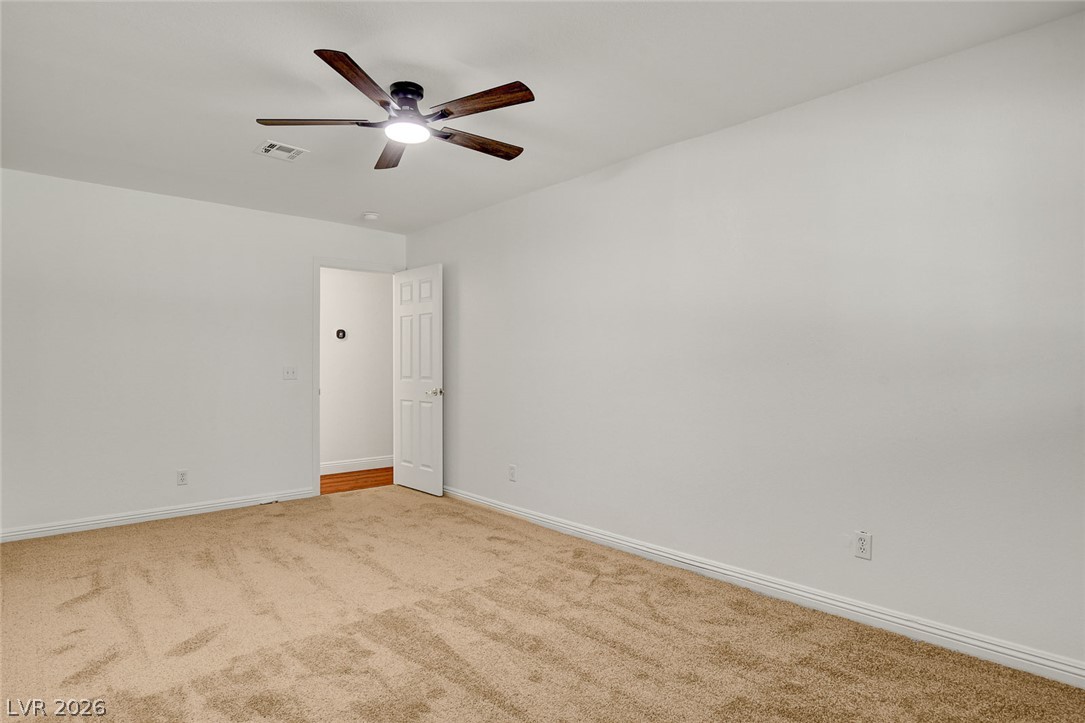 1810 Pinto Road Henderson, NV 89002 - Photo 31 of 53 A well-proportioned bedroom with soft carpeting and a ceiling fan for comfort.