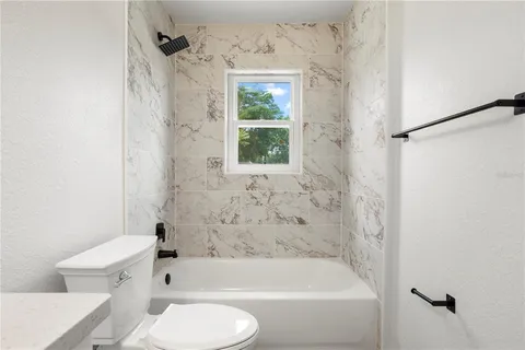 a bathroom with a bathtub toilet and shower