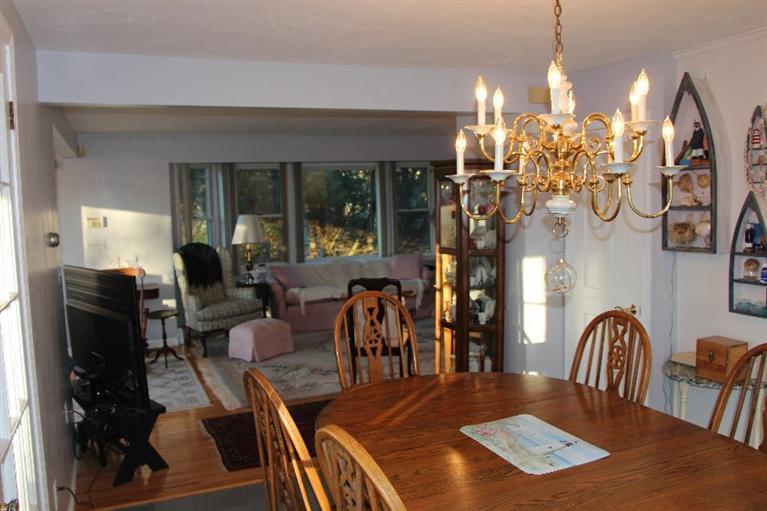 40 Carlisle Road Bourne, MA 02532 - Photo 6 of 28 a view of a dining room with furniture a chandelier and wooden floor