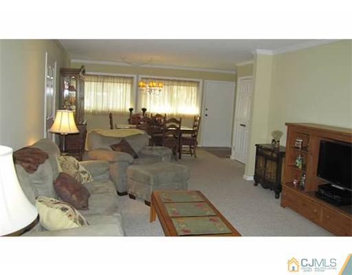 18 Cranston Road Kendall Park, NJ 08824 - Photo 10 of 25 a living room with furniture a flat screen tv and a fireplace