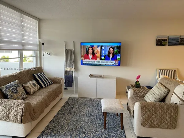 a living room with furniture and a painting on the wall