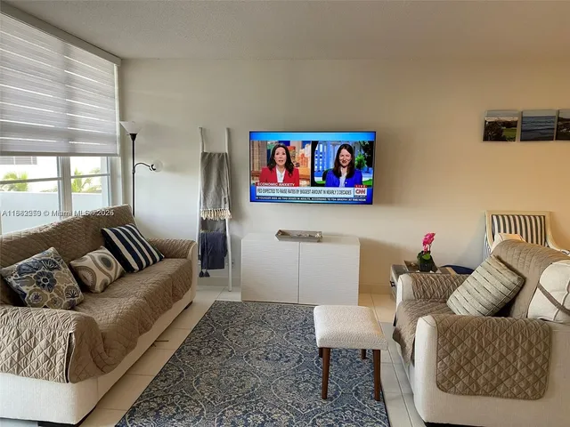 a living room with furniture and a painting on the wall