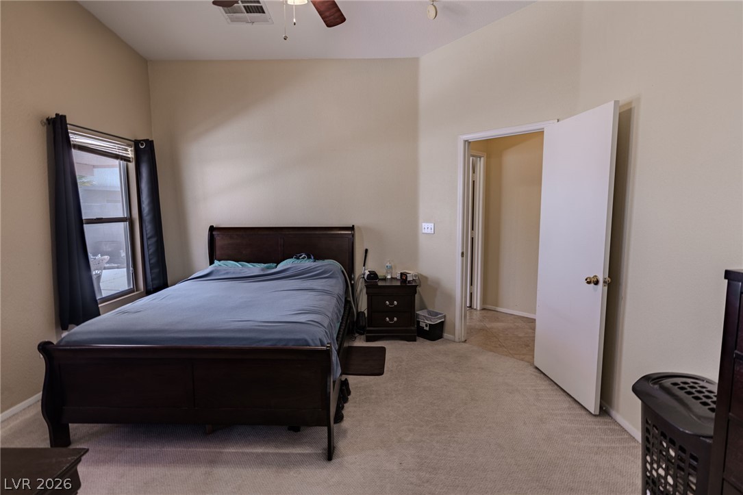 4994 Mascaro Drive Las Vegas, NV 89122 - Photo 13 of 30 A restful bedroom with vaulted ceilings and a clear passage to adjoining spaces.