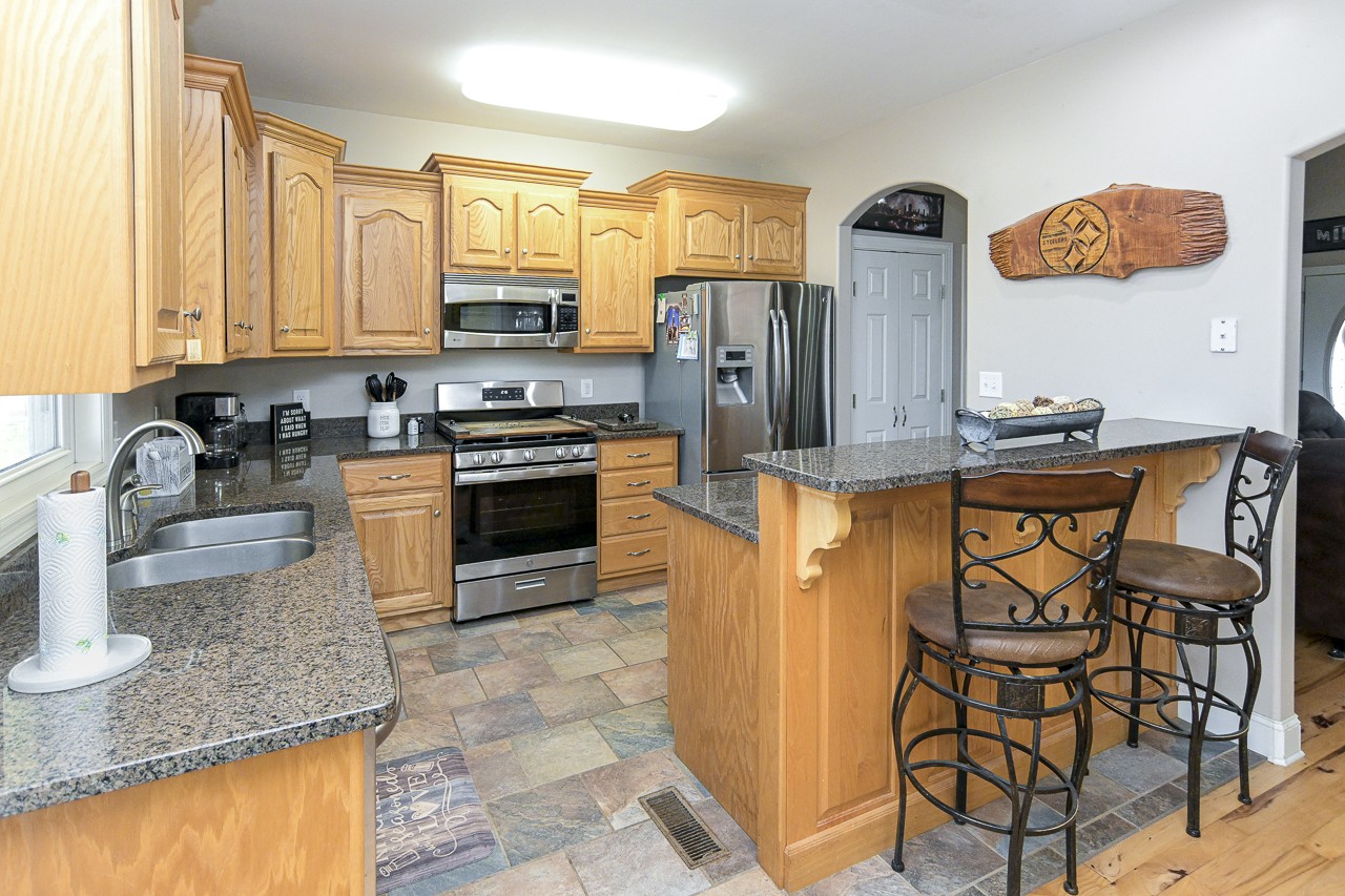 182 Old Camargo Road Fayetteville, TN 37334 - Photo 8 of 59 a kitchen with stainless steel appliances granite countertop a stove top oven a sink a dining table and chairs with wooden floor