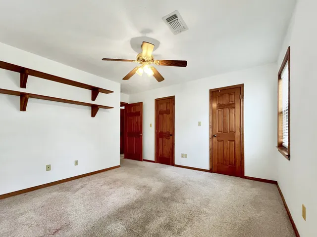 a view of a room with a ceiling fan and a window