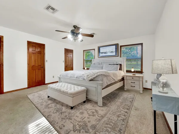 a spacious bedroom with a bed and a chandelier