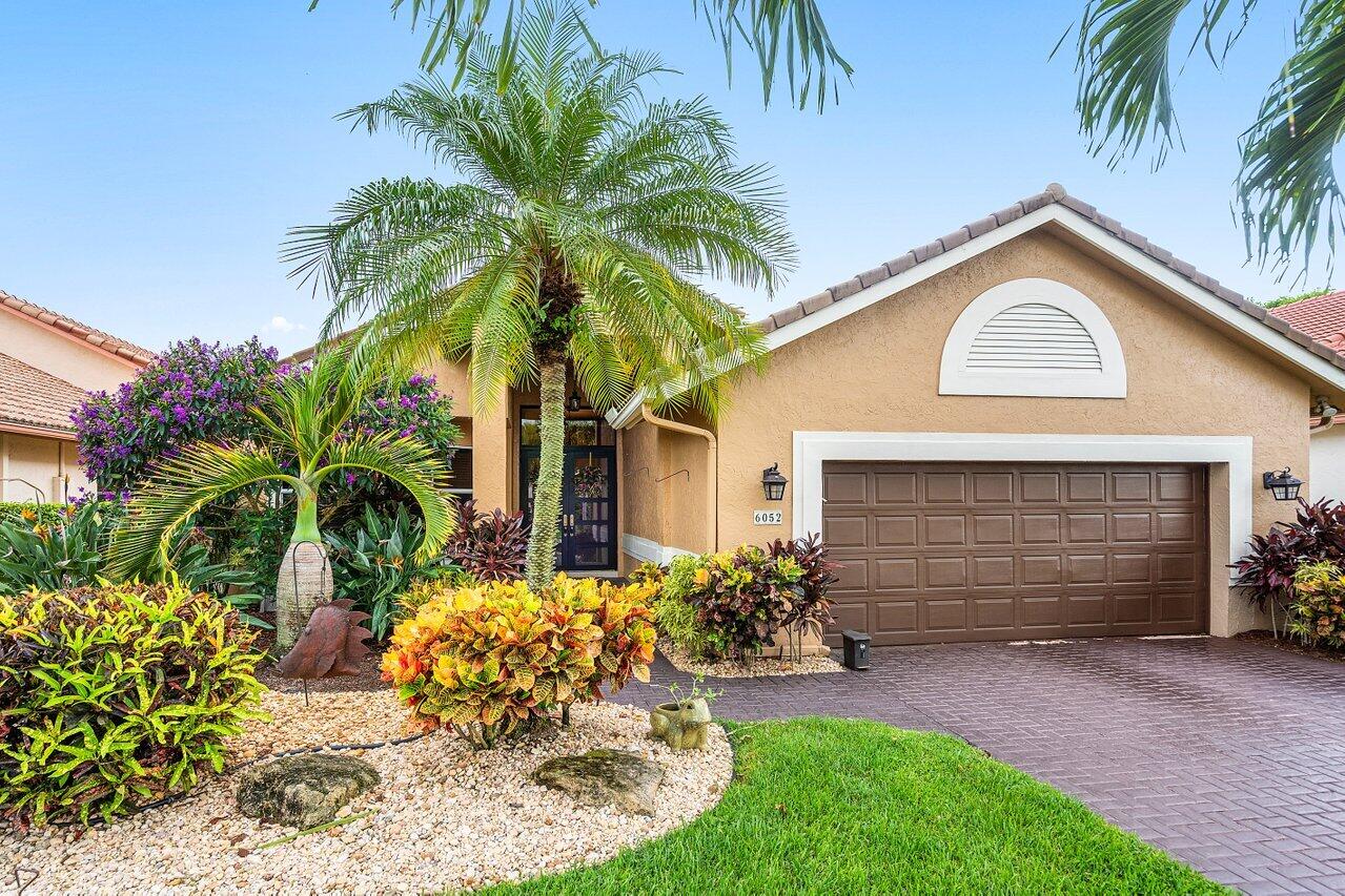 6052 Terra Mere Circle Boynton Beach, FL 33437 - Photo 1 of 52 a front view of a house with a garden