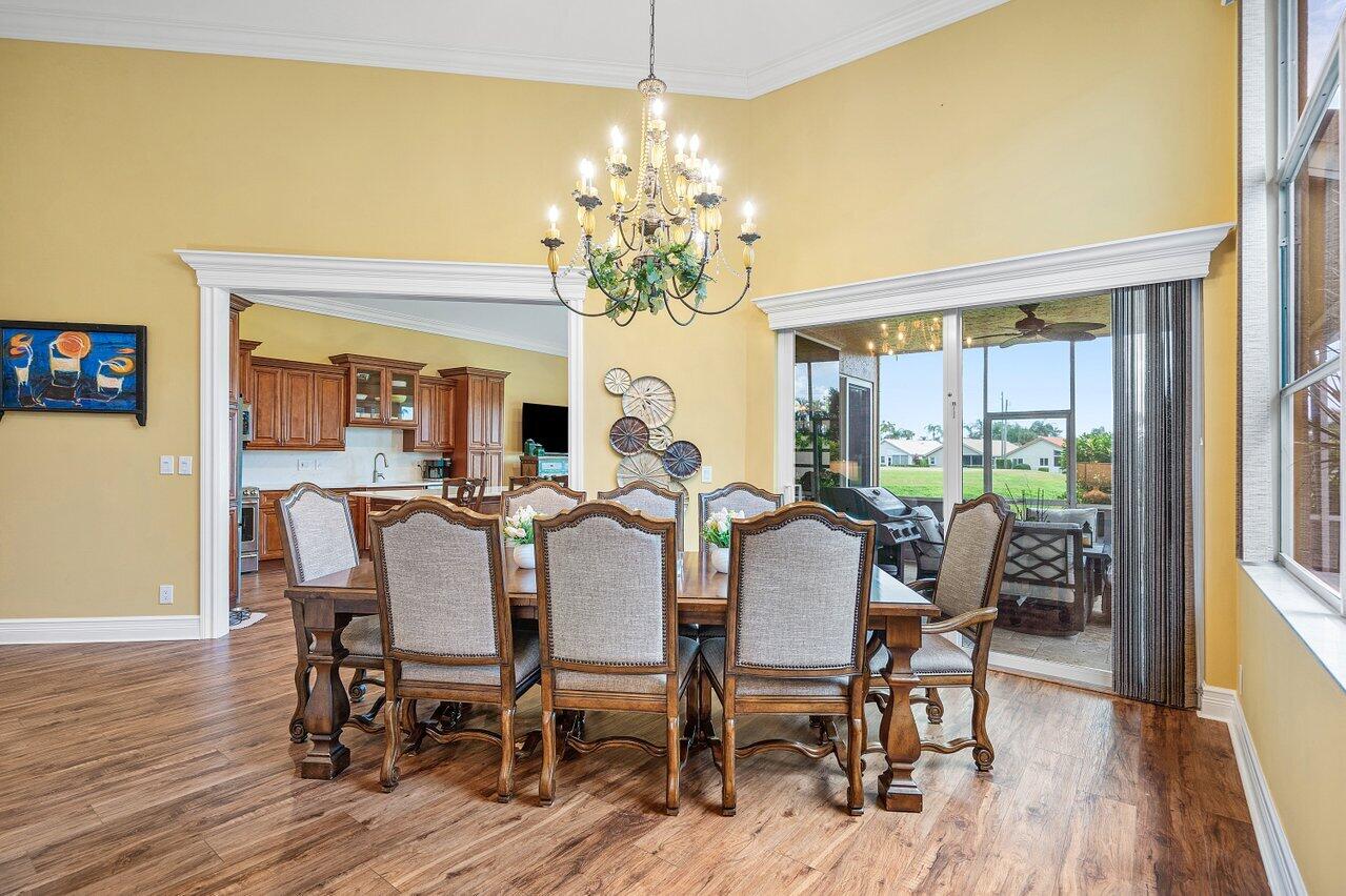 6052 Terra Mere Circle Boynton Beach, FL 33437 - Photo 12 of 52 a view of a dining room with furniture wooden floor and chandelier