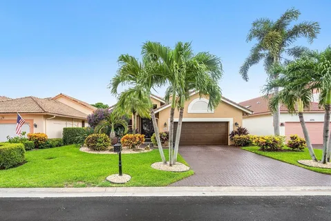 a front view of a house with garden and trees