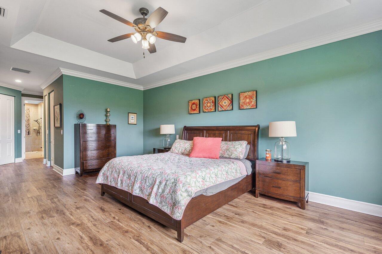 6052 Terra Mere Circle Boynton Beach, FL 33437 - Photo 23 of 52 a bedroom with a bed and a chandelier