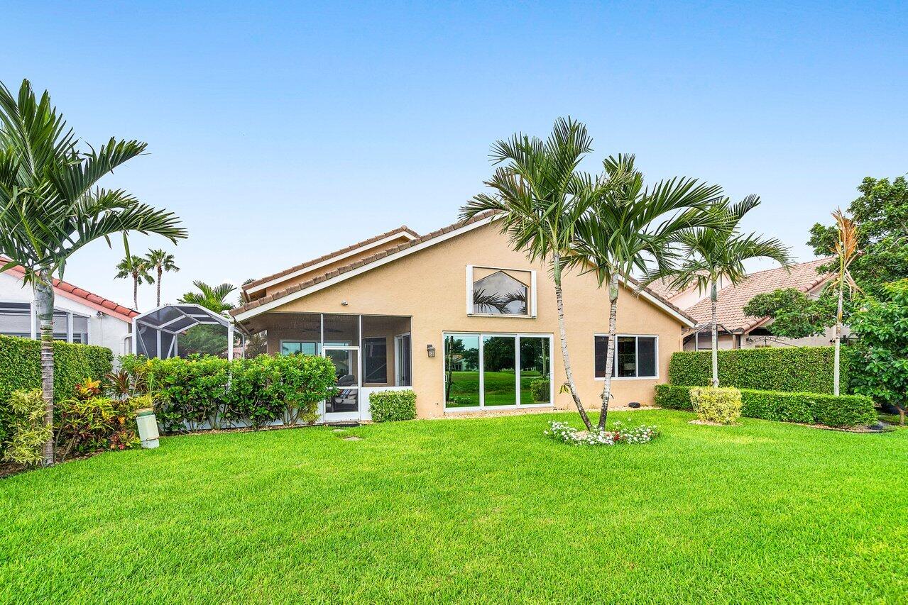 6052 Terra Mere Circle Boynton Beach, FL 33437 - Photo 39 of 52 a front view of a house with a garden and trees