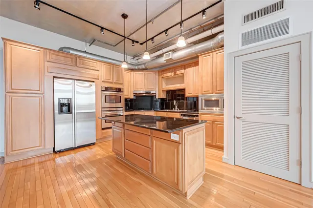 a kitchen with stainless steel appliances granite countertop a refrigerator a oven a sink and dishwasher