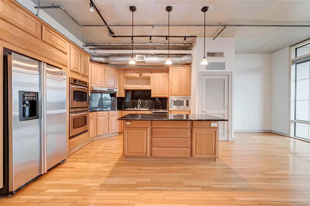 a kitchen with stainless steel appliances granite countertop white cabinets and a window