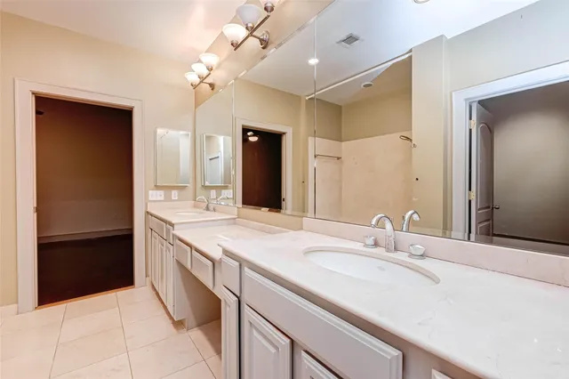 an empty room with a chandelier fan and wooden floor