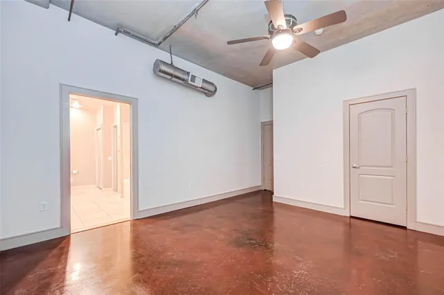 an empty room with a windows and ceiling fan