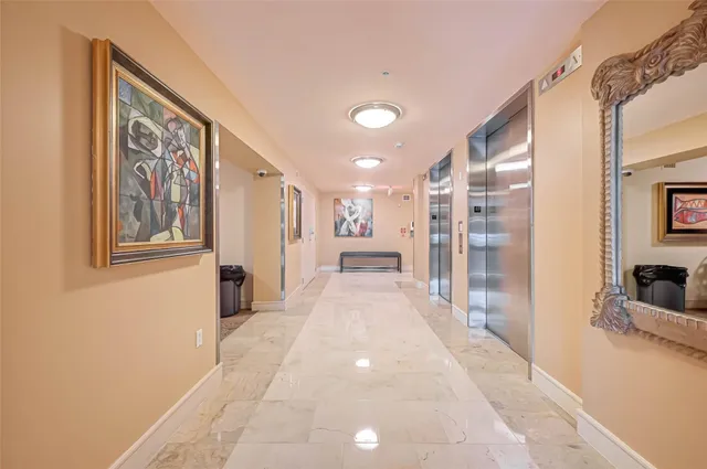a view of a hallway with wooden floor and a living room