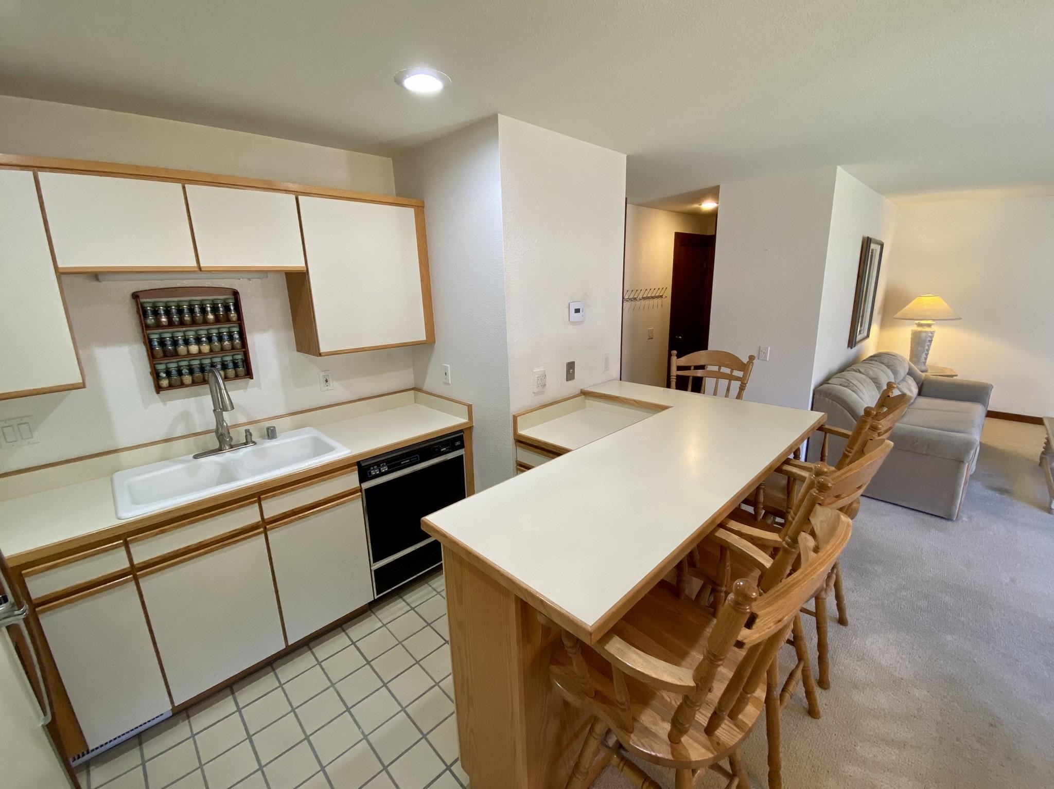 1591 Olympic Vly Road, Unit 28 Olympic Valley, CA 96146 - Photo 7 of 18 a kitchen with a dining table chairs and white appliances