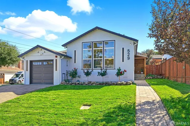 a front view of a house with a yard and garage