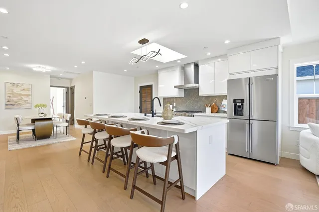 a kitchen with stainless steel appliances kitchen island a table and chairs in it
