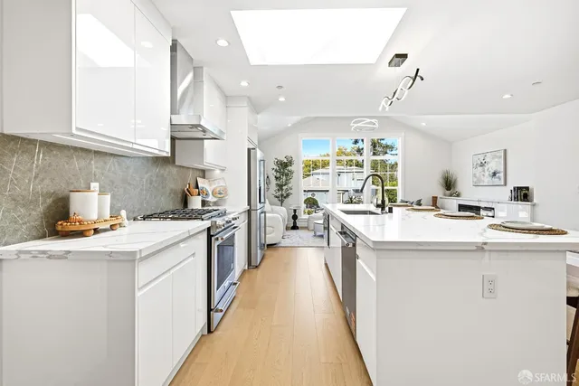 a kitchen with kitchen island a sink stove and cabinets