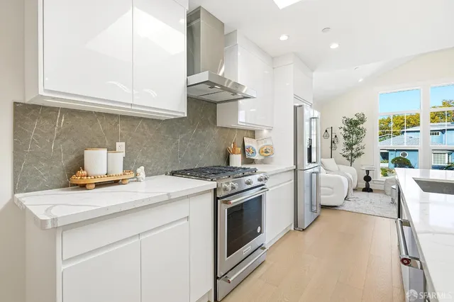 a kitchen with stainless steel appliances granite countertop a stove a sink and a white cabinets