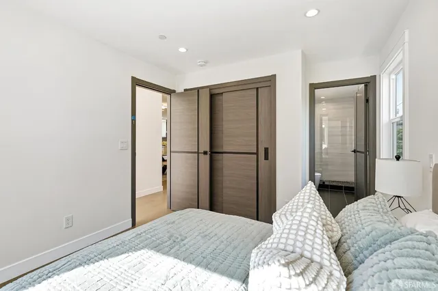 a bedroom with a bed and wooden floor