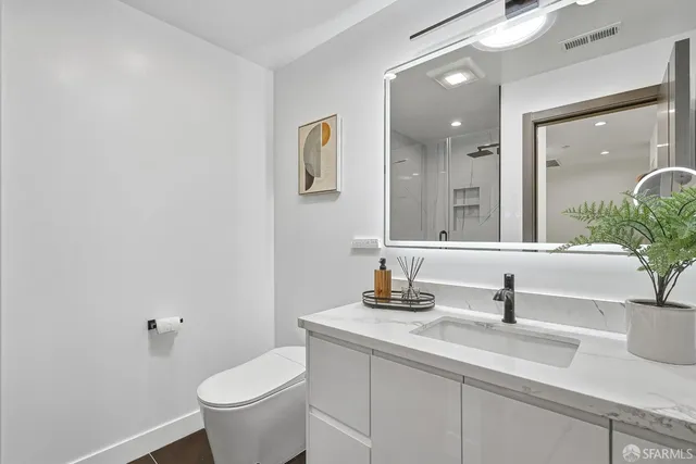 a bathroom with a toilet sink and mirror