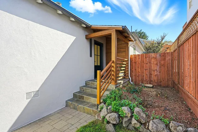 a view of wooden house with a small yard