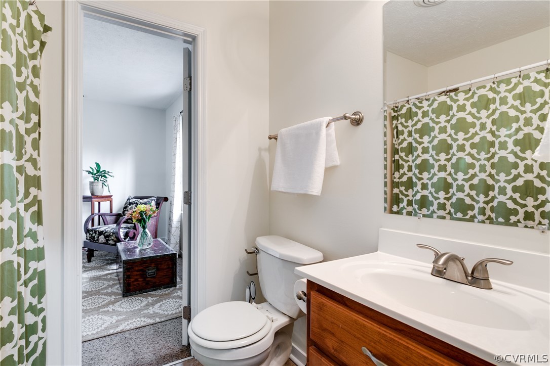 13835 Happy Hill Road Chester, VA 23831 - Photo 24 of 35 a bathroom with a sink a toilet and shower curtain