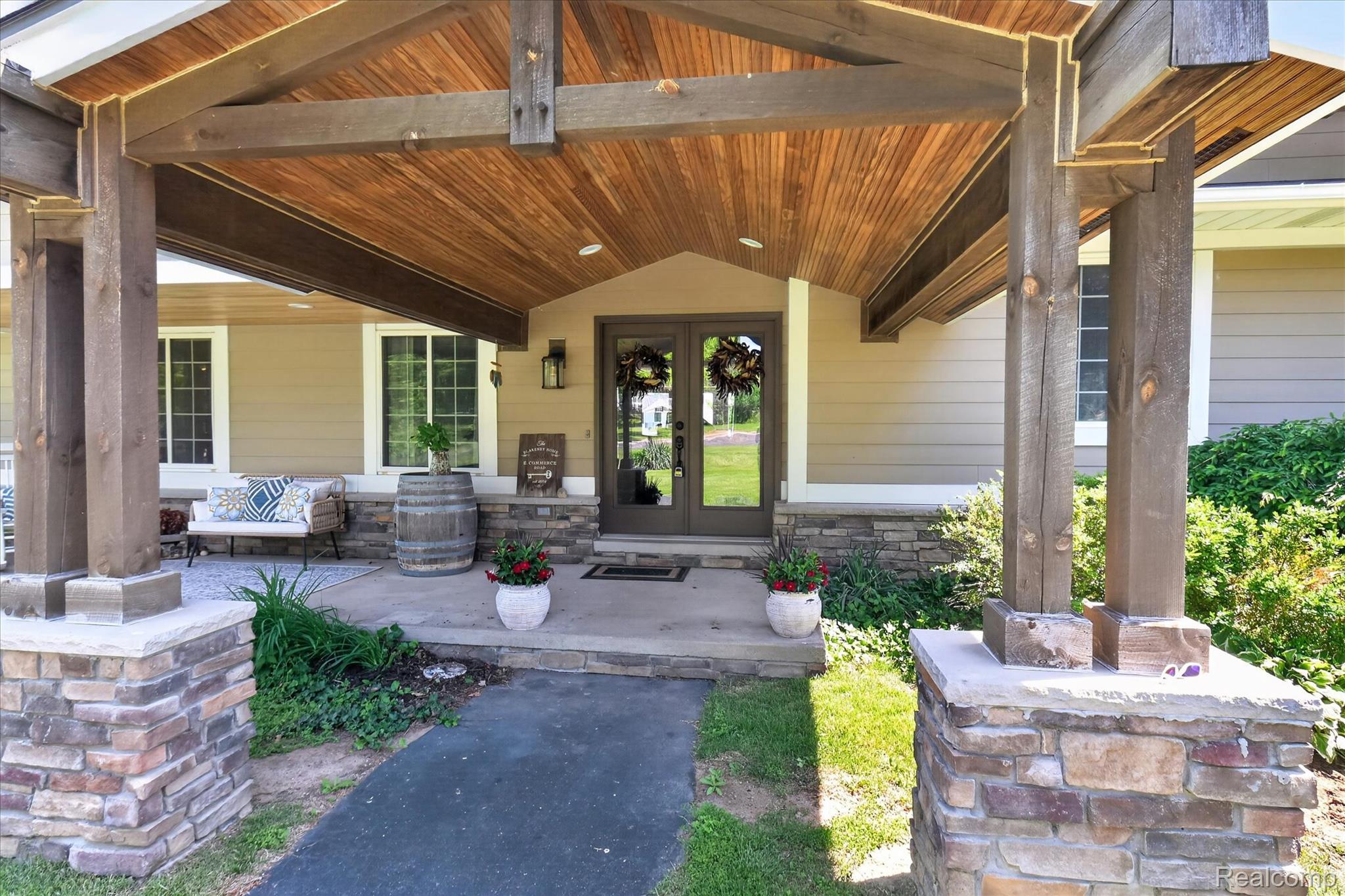 3860 East Commerce Road Commerce Township, MI 48382 - Photo 5 of 72 Expansive covered entry porch featuring exposed wood beam construction and a wood-finish ceiling