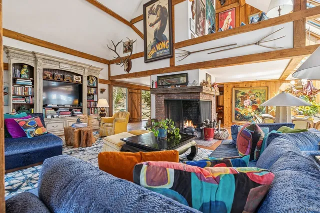a living room with furniture a fireplace and a ceiling fan