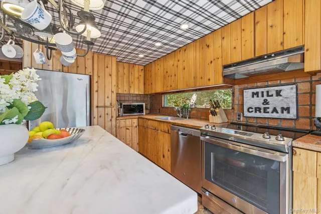 a kitchen with stainless steel appliances granite countertop a sink a stove and a refrigerator