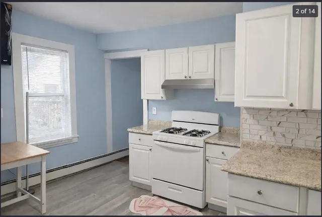 a kitchen with white cabinets and white appliances