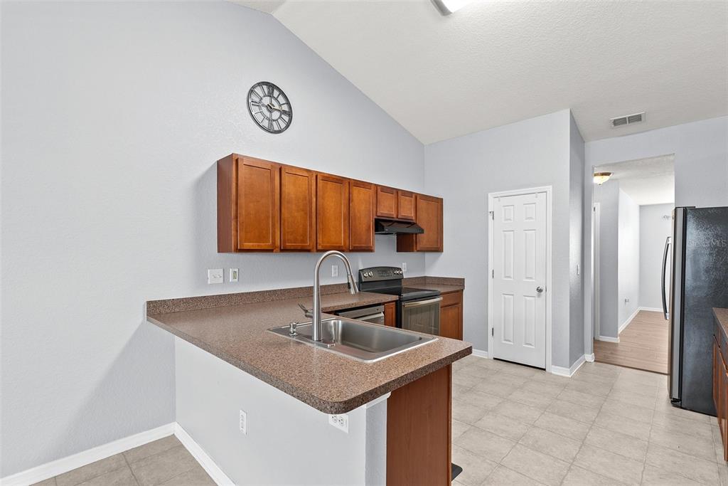 11366 Riddle Drive Spring Hill, FL 34609 - Photo 16 of 49 a kitchen with stainless steel appliances granite countertop a sink a stove and a refrigerator