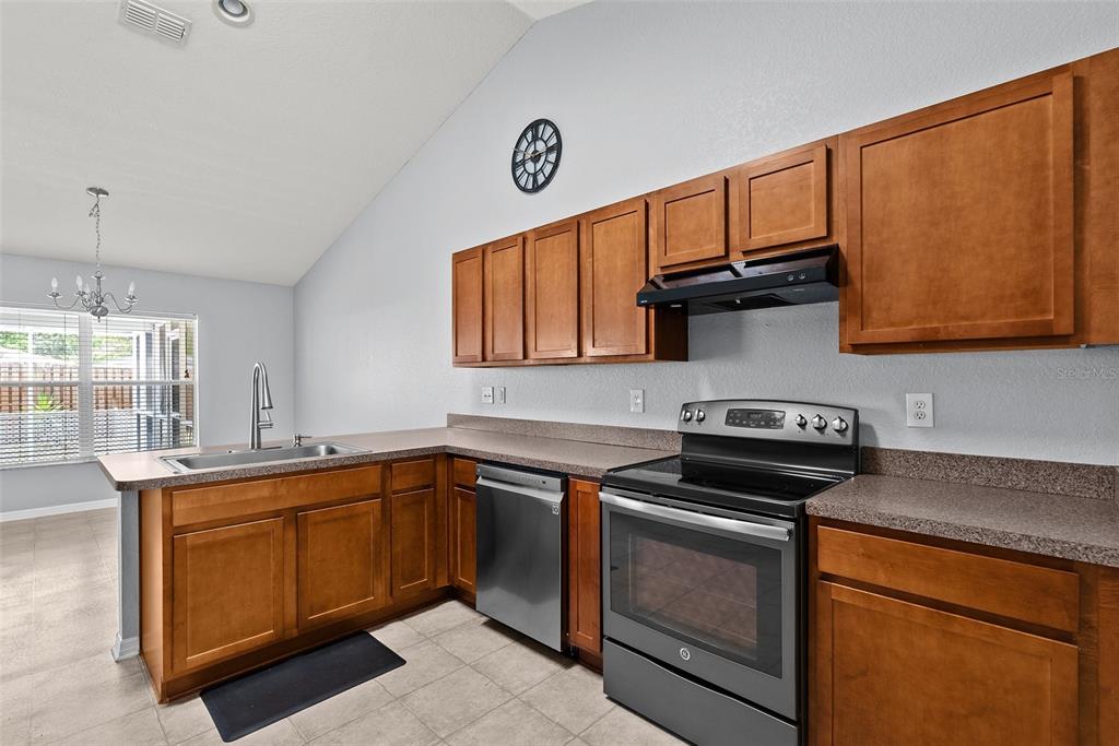 11366 Riddle Drive Spring Hill, FL 34609 - Photo 17 of 49 a kitchen with stainless steel appliances granite countertop a sink stove and cabinets