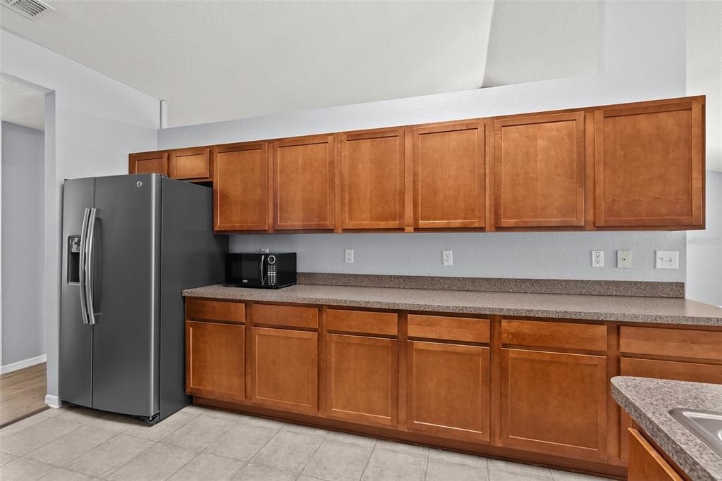 11366 Riddle Drive Spring Hill, FL 34609 - Photo 18 of 49 a kitchen with stainless steel appliances granite countertop a refrigerator and cabinets
