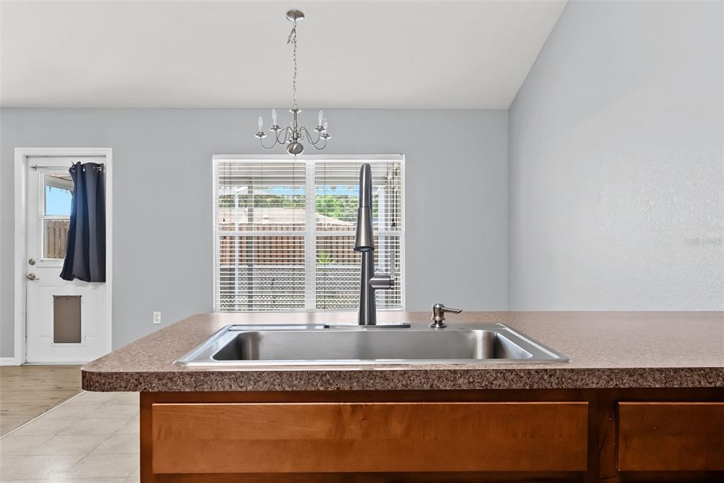 11366 Riddle Drive Spring Hill, FL 34609 - Photo 19 of 49 a view of a kitchen with granite countertop a sink and dishwasher with wooden floor