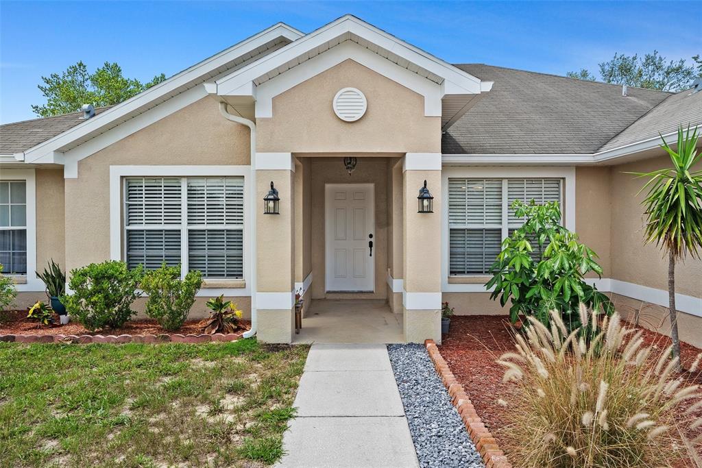 11366 Riddle Drive Spring Hill, FL 34609 - Photo 2 of 49 a view of a house with a small yard and plants