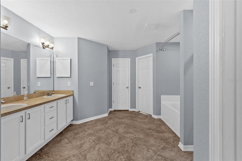 11366 Riddle Drive Spring Hill, FL 34609 - Photo 25 of 49 a bathroom with a granite countertop sink a toilet a large mirror a shower and vanity