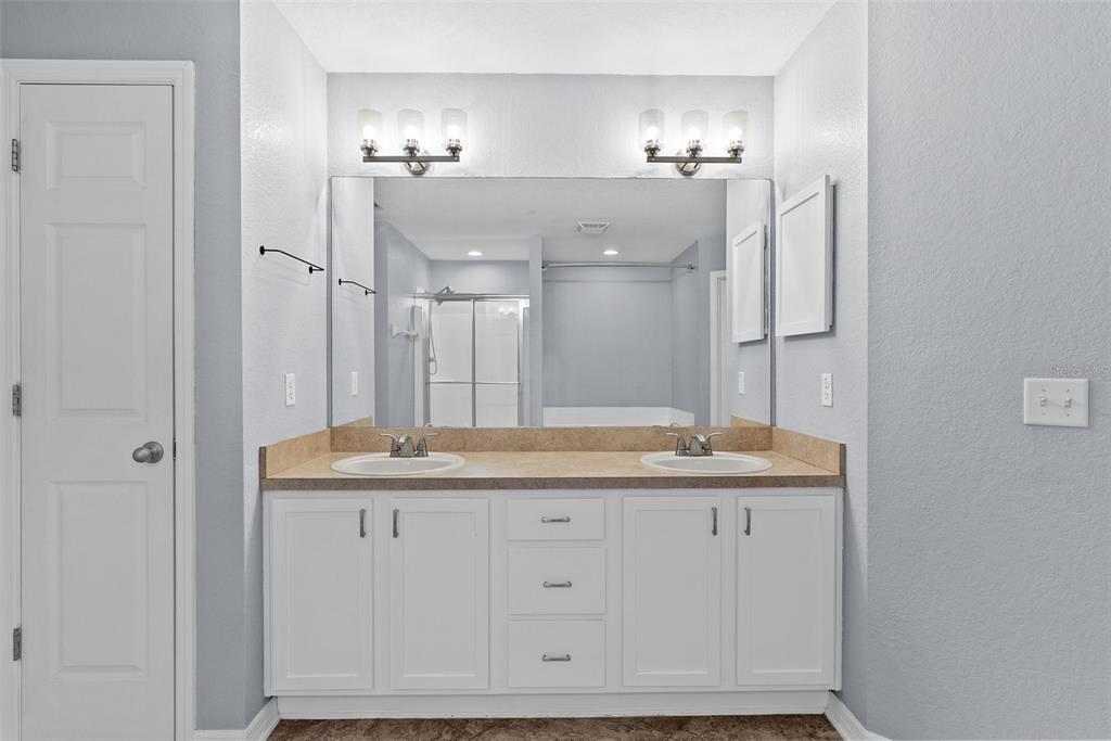 11366 Riddle Drive Spring Hill, FL 34609 - Photo 26 of 49 a bathroom with a granite countertop shower sink and mirror