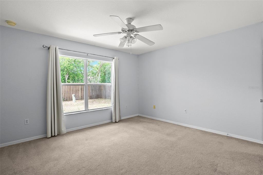 11366 Riddle Drive Spring Hill, FL 34609 - Photo 33 of 49 an empty room with windows and ceiling fan