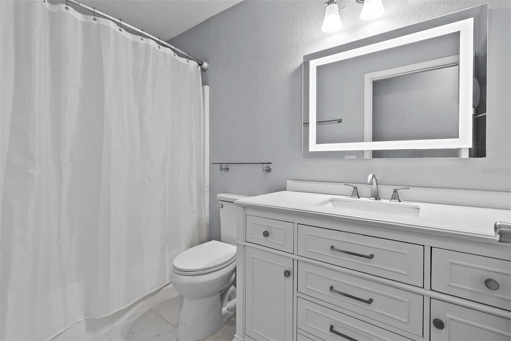 11366 Riddle Drive Spring Hill, FL 34609 - Photo 35 of 49 a bathroom with a toilet a sink a vanity and mirror