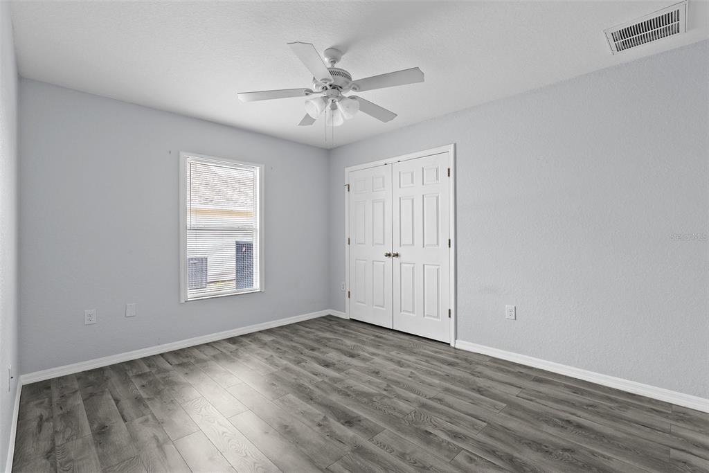 11366 Riddle Drive Spring Hill, FL 34609 - Photo 38 of 49 a view of an empty room with wooden floor and a window