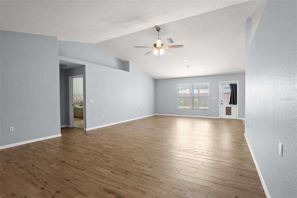11366 Riddle Drive Spring Hill, FL 34609 - Photo 10 of 49 a view of empty room with wooden floor and fan
