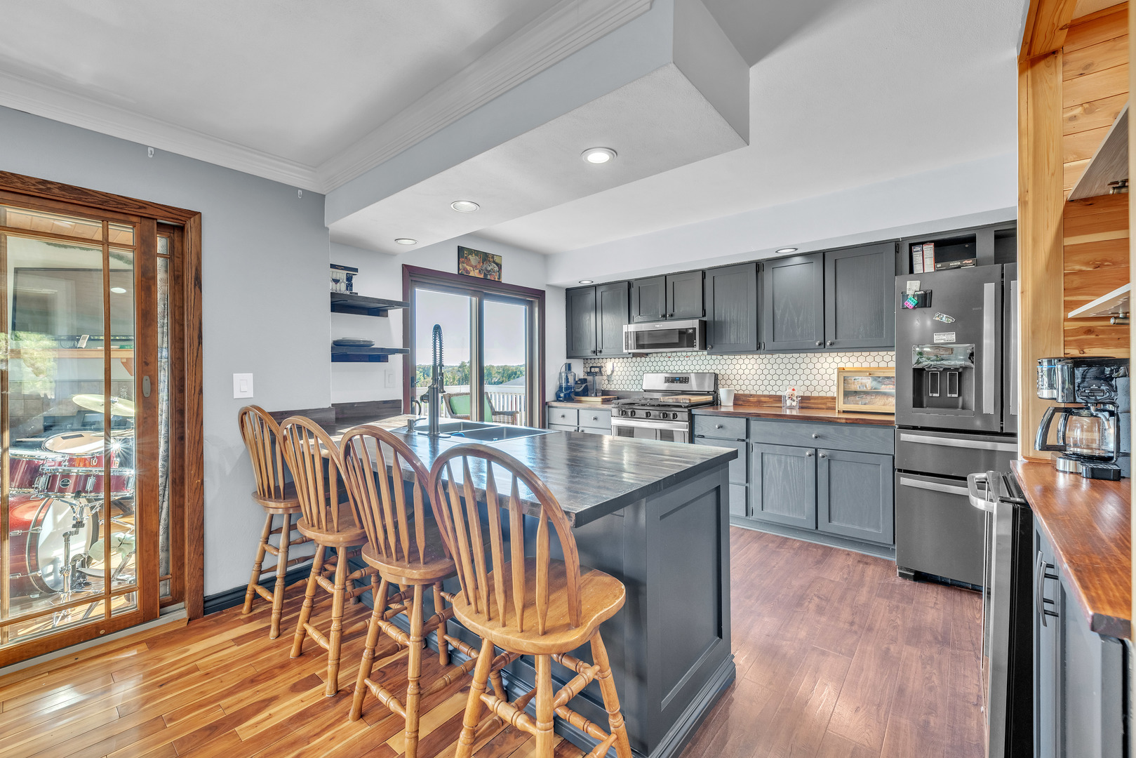 6338 Thicket Lane Cherry Valley, IL 61016 - Photo 9 of 43 a kitchen with stainless steel appliances granite countertop a stove top oven a sink dishwasher a dining table and chairs with wooden floor