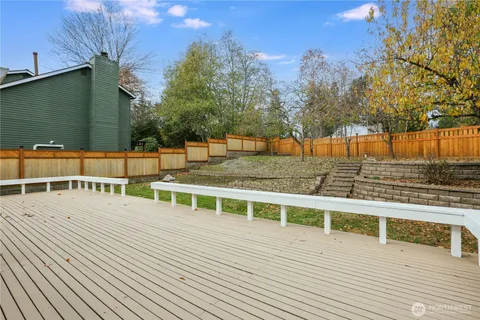 a view of a balcony with wooden floor and trees