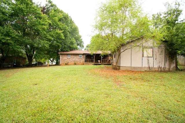 a front view of house with yard and trees in the background