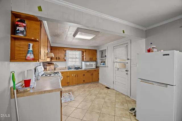 a kitchen with white cabinets appliances and a window