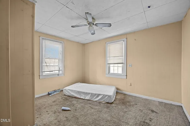 a bedroom with a bed and a chandelier fan
