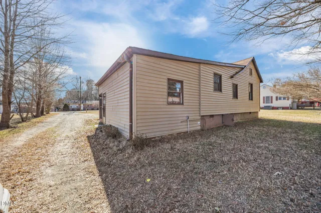 a view of a wooden house with large trees